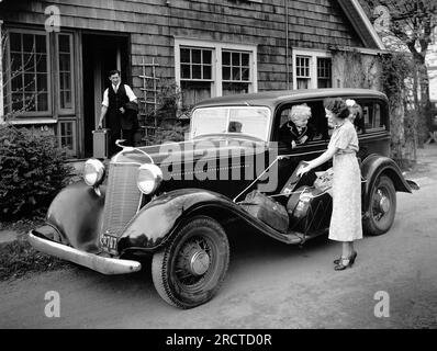 Connecticutt: ca. 1933 Eine vierköpfige Familie, die in ihrem DeSoto-Automobil in den Urlaub fährt. Stockfoto