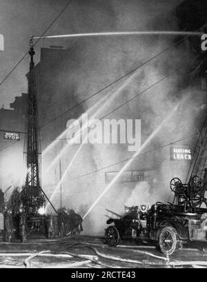 Syracuse, New York: 25. Januar 1924 Feuerwehrautos und Feuerwehrmänner kämpfen im Manhattan Hotel und Electric Lunch Cafe im Zentrum von Syracuse gegen eine Explosion im Jahr $150.000. Stockfoto