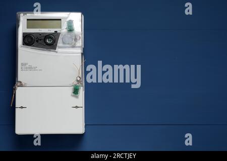Stromzähler an blauer Holzwand, Platz für Text Stockfoto