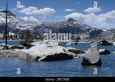 Aloha-See mit Felsbrocken im blauen Wasser und umgeben die schneebedeckten Alpenberge. Stockfoto