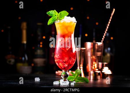 Aruba Ariba alkoholisches Cocktailgetränk mit Wodka, weißem Rum, Orangen-, Zitronen- und Ananassaft, Grenadine, dunkler Bartheke Hintergrund, Kopierbereich Stockfoto