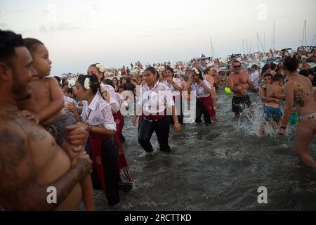 Malaga, Spanien. 16. Juli 2023. Die Brüder „Virgen del Carmen“ sehen, wie sie den Strand verlassen, nachdem sie die Prozession im Viertel „El Palo“ beendet haben. Jedes Jahr, am 16. Juli, feiert Malaga ein religiöses Fest zu Ehren der „Virgen del Carmen“, Schutzpatron der Seeleute und Fischer. Die Statue der Jungfrau, getragen von einer Gruppe von Gläubigen in traditionellen Kostümen entlang der Straßen, wird auf einem Boot vom Strand platziert, das später die Küste Malagas hinunter segelt. Kredit: SOPA Images Limited/Alamy Live News Stockfoto