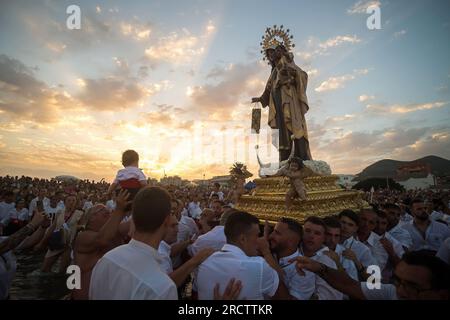 Malaga, Spanien. 16. Juli 2023. Die Brüder „Virgen del Carmen“, die die Statue der Jungfrau tragen, werden am Strand gesehen, während sie an einer Prozession im Viertel „El Palo“ teilnehmen. Jedes Jahr, am 16. Juli, feiert Malaga ein religiöses Fest zu Ehren der „Virgen del Carmen“, Schutzpatron der Seeleute und Fischer. Die Statue der Jungfrau, getragen von einer Gruppe von Gläubigen in traditionellen Kostümen entlang der Straßen, wird auf einem Boot vom Strand platziert, das später die Küste Malagas hinunter segelt. Kredit: SOPA Images Limited/Alamy Live News Stockfoto