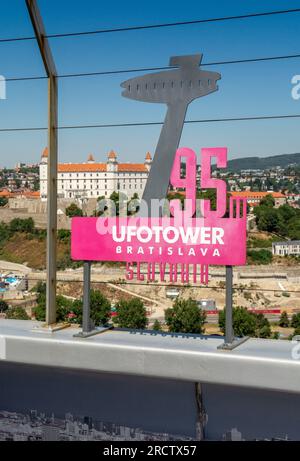 Bratislava, Slowakei - 15. Juli 2023 : UFO-TURMSCHILD mit Schloss Bratislava im Hintergrund. Stockfoto