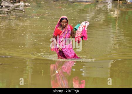 Morigaon. 16. Juli 2023. Am 16. Juli 2023 waten Frauen im nordöstlichen indischen Bundesstaat Assam in einem von der Flut betroffenen Dorf im Bezirk Morigaon im Wasser. Kredit: Str/Xinhua/Alamy Live News Stockfoto