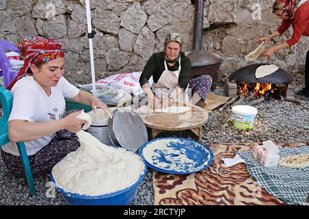 Beytussebap, Truthahn. 14. Juli 2023. Kurdische Frauen werden dabei gesehen, wie sie kurdisches Brot für die Teilnehmer des Festivals backen, wo auch Rojins Konzert stattfand. Der berühmte kurdische Sänger Rojin (Rojin Ulker) hielt ein Konzert auf einem Festival im Stadtteil Beytussebap der türkischen Provinz Sirnak. Türkische und kurdische Gesangslieder Rojins öffentliches Konzert im Freien wurde von Tausenden von Menschen begeistert beobachtet. Rojin, ein türkischer Bürger, lebt seit einiger Zeit in der kurdischen Bundesregion Irak. (Foto: Mehmet Masum Suer/SOPA Images/Sipa USA) Guthaben: SIPA USA/Alamy Live News Stockfoto