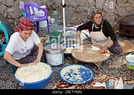 Beytussebap, Truthahn. 14. Juli 2023. Kurdische Frauen werden dabei gesehen, wie sie kurdisches Brot für die Teilnehmer des Festivals backen, wo auch Rojins Konzert stattfand. Der berühmte kurdische Sänger Rojin (Rojin Ulker) hielt ein Konzert auf einem Festival im Stadtteil Beytussebap der türkischen Provinz Sirnak. Türkische und kurdische Gesangslieder Rojins öffentliches Konzert im Freien wurde von Tausenden von Menschen begeistert beobachtet. Rojin, ein türkischer Bürger, lebt seit einiger Zeit in der kurdischen Bundesregion Irak. Kredit: SOPA Images Limited/Alamy Live News Stockfoto