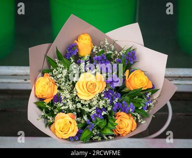 Strauß gelber Rosen mit "Vergiss mich", nicht in einem Blumenladen. Stockfoto