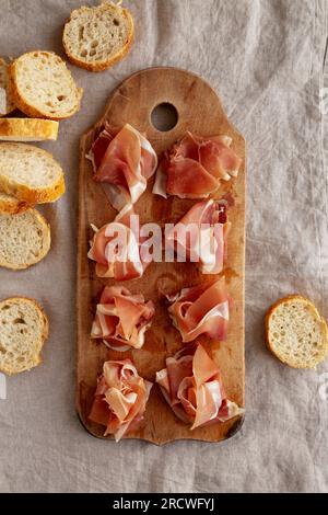 Scheiben von appetitanregenden Jamon Serrano bereit zum Essen auf einem rustikalen Holzbrett, Blick von oben. Flach liegend, über Kopf, von oben. Stockfoto