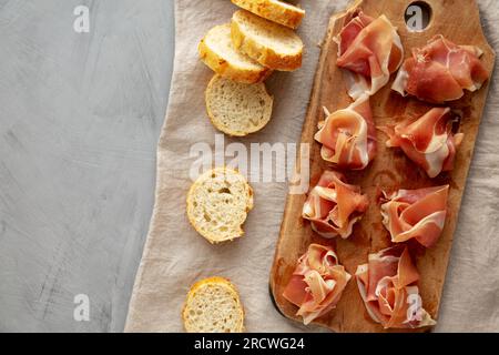 Scheiben von appetitanregenden Jamon Serrano bereit zum Essen auf einem rustikalen Holzbrett, Blick von oben. Flach liegend, über Kopf, von oben. Stockfoto