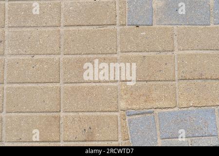Texturfliesen auf der Straße, warmer Schatten, Draufsicht, Nahaufnahme. Stockfoto