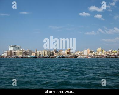 Moderne Gebäude an der Küste der Bucht deira Creek und traditionelle Boote in Dubai, Vereinigte Arabische Emirate Stockfoto