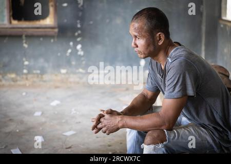 Deprimierter und hoffnungsloser Mann allein im Dunkeln, einsamer Mann Silhouette auf dem Bett, depressiv und gestresst im dunklen Schlafzimmer, Depression Stockfoto