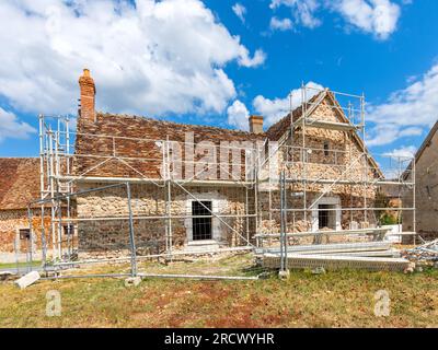 Gerüste rund um das alte Landhaus, das renoviert wird - Rosnay, Indre (36), Frankreich. Stockfoto