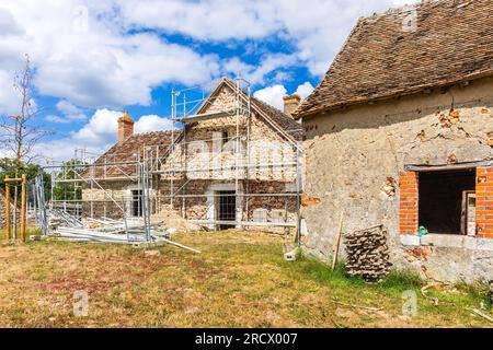 Gerüste rund um das alte Landhaus, das renoviert wird - Rosnay, Indre (36), Frankreich. Stockfoto