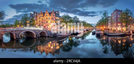 Amsterdam. Panoramablick auf das historische Stadtzentrum von Amsterdam. Traditionelle Häuser und Brücken von Amsterdam. Ein blauer Abend und die Ruhe Stockfoto