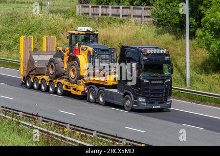 2019 „Argyll Style“ Scania Diesel 16353 ccm Muldenkipper mit knickgelenktem Tieflader STGO CAT 2 und HYUNDAI HL960 Radladern auf der Autobahn M6 im Großraum Manchester, Großbritannien Stockfoto