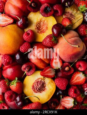 Nahaufnahme gemischter Sommerfrüchte: Beeren, Pfirsiche, Kirschen. Stockfoto