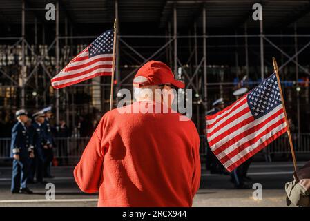 Ein älterer Mann winkt bei der Veteran's Day Parade in New York City mit der amerikanischen Flagge Stockfoto