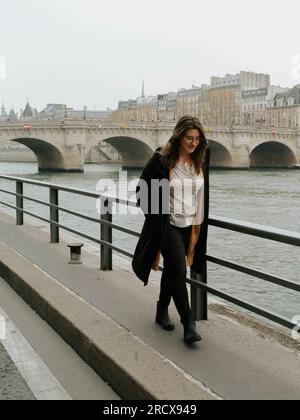 Eine amerikanische Frau geht in Paris entlang der seine Stockfoto