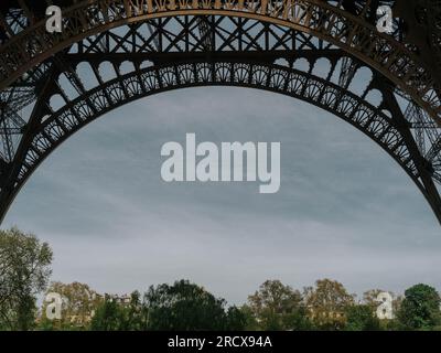 Atemberaubende Aussicht durch den unteren Bogen des Eiffelturms, Stockfoto