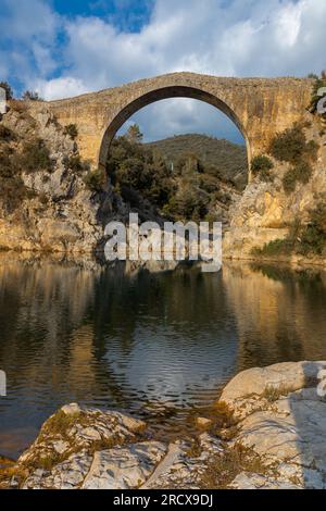 Blick auf eine alte Brücke Pont de Llierca in Katalonien, Spanien. Diese schöne Brücke, gepflastert mit Sandsteinplatten, ist seit dem 14.. Jahrhundert in Gebrauch. Stockfoto