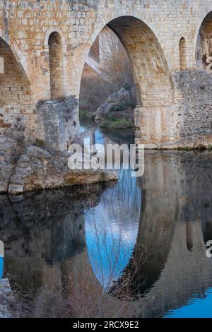 Blick auf eine alte Brücke Pont de Llierca in Katalonien, Spanien. Diese schöne Brücke, gepflastert mit Sandsteinplatten, ist seit dem 14.. Jahrhundert in Gebrauch. Stockfoto