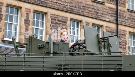 Redford Barracks, Edinburgh, Schottland, Vereinigtes Königreich, 17. Juli 2023. Army at the Fringe: Darsteller einer Show auf dem Edinburgh Festival Fringe, Mitglied der Besetzung (Rebecca Wilkie) von Everything Under the Sun (über die UN-Friedensmission in Mali), mit einem Gewehr auf einem riesigen, gepanzerten Mastiff-Fahrzeug, das den Bedrohungen durch Bomben am Straßenrand entgegenwirkt. Kredit: Sally Anderson/Alamy Live News Stockfoto