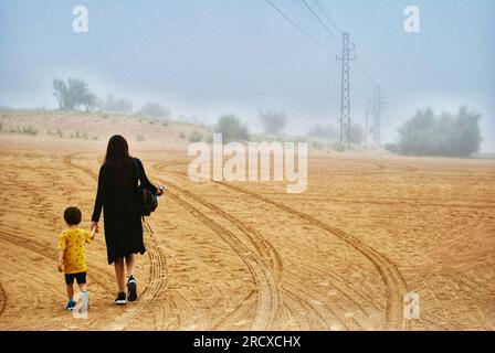 Eine Frau und ein Kind wandern in der Wüste von Dubai Stockfoto