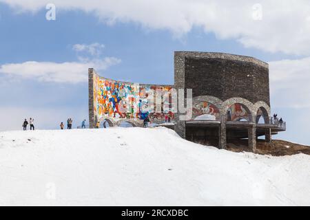 Gudauri, Georgien - 1. Mai 2019: Touristen besuchen das Russland-Georgien-Denkmal der Freundschaft oder das georgische Vertragsdenkmal. Es liegt an der georgischen Stockfoto