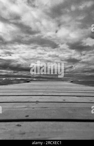 Hölzerner Pier gegen Sturmwolken, die auf dem Karenjarvi-See Kuhmo Finland liegen. Juni 2023. Stockfoto