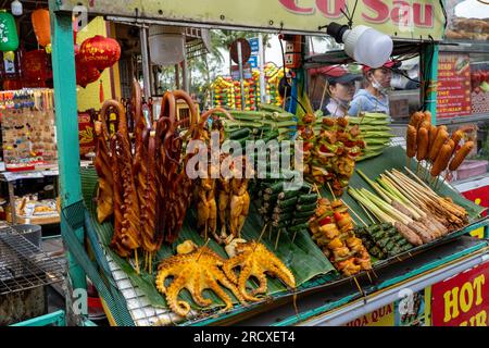 Würdest du etwas davon essen? Farbenfrohe Street Food-Stände in Hoi an, Vietnam, die einige farbenfrohe, aber ungeschmackvolle Speisen verkaufen. Stockfoto