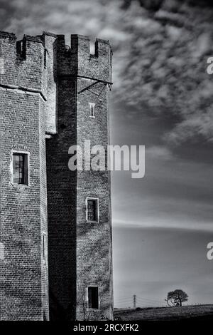 Monochromblick auf einen Turm gegen den Himmel, der am 17. April 2023 im Schloss Herstmonceux in East Sussex (Großbritannien) fotografiert wurde. Bild von Julie Edwards. Stockfoto