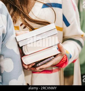 Nahaufnahme des Buchstapels in den Händen junger Studentenbuchhandlung. Lesen als Hobby Stockfoto