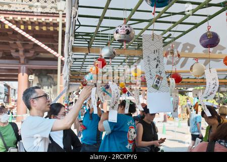 Kawasaki, Japan. 17. Juli 2023. Ein Kunde prüft am 17. Juli 2023 die Windspiele auf dem Markt „Furin-Ichi“ in den Bezirken des Kawasaki Daishi Heikenji Tempels in Kawasaki, Präfektur Kanagawa, Japan. Windspiele werden auf 800 Arten und 20.000 Stück verkauft. Foto: Keizo Mori/UPI Credit: UPI/Alamy Live News Stockfoto