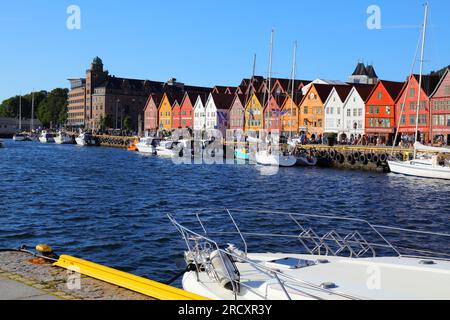 BERGEN, NORWEGEN - 23. JULI 2020: Besucher besuchen den Stadtteil Bryggen in Bergen, Norwegen. Es ist ein UNESCO-Weltkulturerbe. Stockfoto