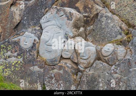 Faces, Rock Art Carvings, Teil des Stone & man-Projekts des lokalen Künstlers alias Høegh auf Qaqortoq, Grönland im Juli Stockfoto