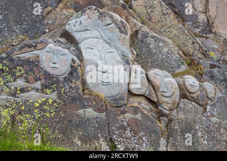 Faces, Rock Art Carvings, Teil des Stone & man-Projekts des lokalen Künstlers alias Høegh auf Qaqortoq, Grönland im Juli Stockfoto