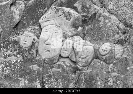 Faces, Rock Art Carvings, Teil des Stone & man-Projekts des lokalen Künstlers alias Høegh auf Qaqortoq, Grönland im Juli - monochrom, schwarz und weiß Stockfoto