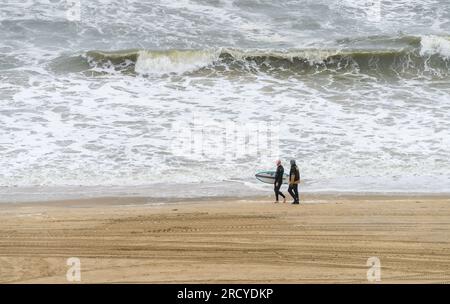 Virginia Beach, VA - 21. Juni 2023: Surfer und Wachmann auf rauer See an einem stürmischen Sommertag Stockfoto