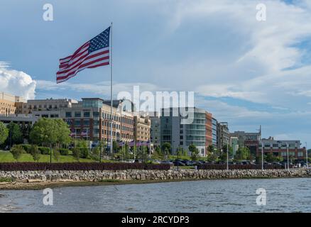 National Harbor, MD - 24. Juni 2023: Skyline des National Harbor mit großer US-Flagge in der Nähe von Washington DC Stockfoto
