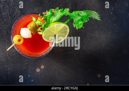 Bloody Mary Cocktail mit Zierleiste auf schwarzem Hintergrund, Overhead Flat Lay Aufnahme mit Kopierbereich. Scharfer Tomatensaft mit Alkohol Stockfoto