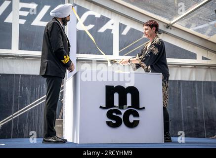 Bremerhaven, Deutschland. 17. Juli 2023. Barinder Pal Singh (l), Kapitän, und Cindy-Jo Cappellini, Patentante und Ehefrau des verstorbenen MSC-Mitarbeiters Michel Cappellini, christen den in China gebauten Megafrachter „MSC Michel Cappellini“. Das Containerschiff ist Teil der neuesten Generation von Schiffen der MSC-Schifffahrtsgesellschaft. Mit einer Länge von etwa 400 Metern, einer Breite von etwa 61 Metern und einem Gesamtfassungsvermögen von 24.346 Standardcontainern ist es eines der größten Containerschiffe, die je gebaut wurden. Kredit: Sina Schuldt/dpa/Alamy Live News Stockfoto