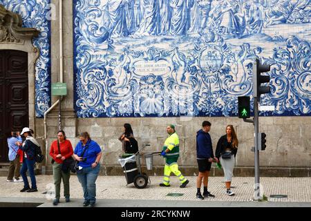 Touristen und Straßenreiniger vor den Asulejos / Keramikfliesen an der Seitenwand der Igreja do Carmo Kirche, Porto / Porto, Portugal Stockfoto