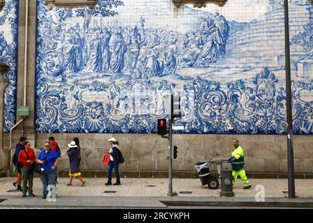 Touristen und Straßenreiniger vor den Asulejos / Keramikfliesen an der Seitenwand der Igreja do Carmo Kirche, Porto / Porto, Portugal Stockfoto