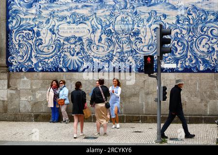 Touristen vor den Asulejos / Keramikfliesen an der Seitenwand der Kirche Igreja do Carmo, Porto / Porto, Portugal Stockfoto