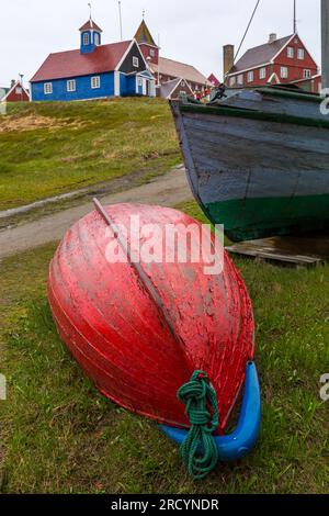 Boote mit der alten blauen Bethal-Kirche und der Colonial Manager Residence im Sisimiut Museum in Sisimiut, Grönland an einem nassen Regentag im Juli Stockfoto