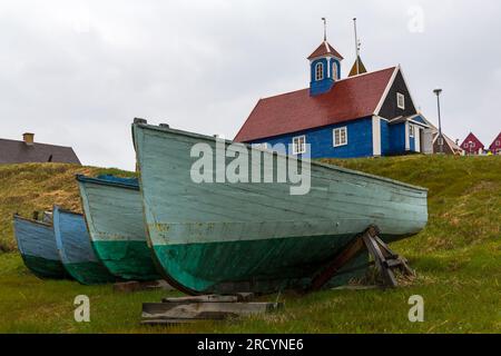 Boote und alte blaue Bethal-Kirche in Sisimiut, Grönland an einem nassen Regentag im Juli Stockfoto