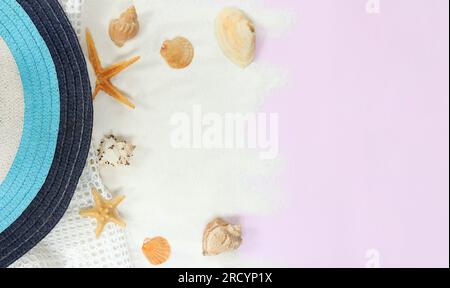 Strandmütze, Mesh und Sand mit Muscheln auf pinkfarbenem Hintergrund im Sommer, Kopierbereich, Draufsicht, minimalistischer Style Stockfoto