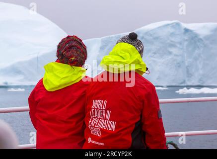 Weltführer in der Erkundung Reisen Sie im Juli auf der Rückseite der roten Hurtigruten-Jacke von Touristen in Ilimanaq, Disko Bay, Grönland Stockfoto